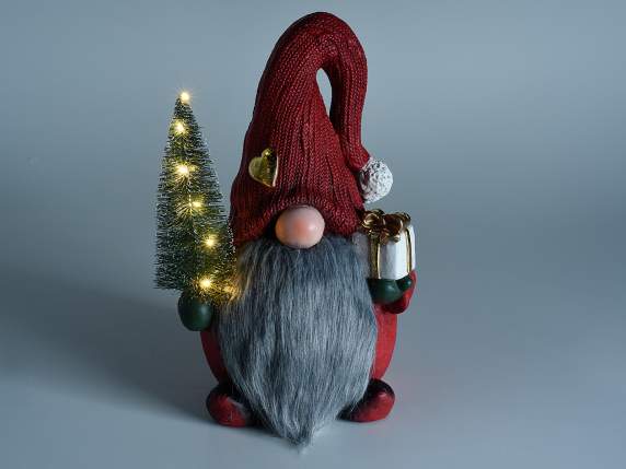 Nain de magnésie avec boîte-cadeau et arbre avec des lumière
